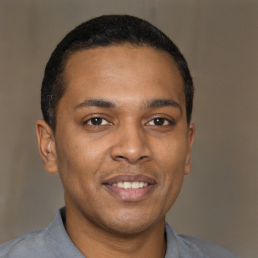 Joyful black young-adult male with short  brown hair and brown eyes
