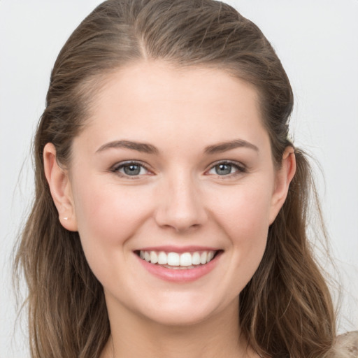 Joyful white young-adult female with long  brown hair and grey eyes