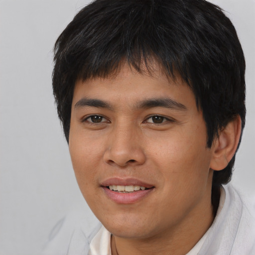 Joyful asian young-adult male with short  brown hair and brown eyes