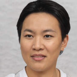 Joyful asian adult female with short  brown hair and brown eyes