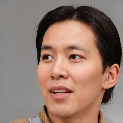Joyful asian adult male with medium  brown hair and brown eyes