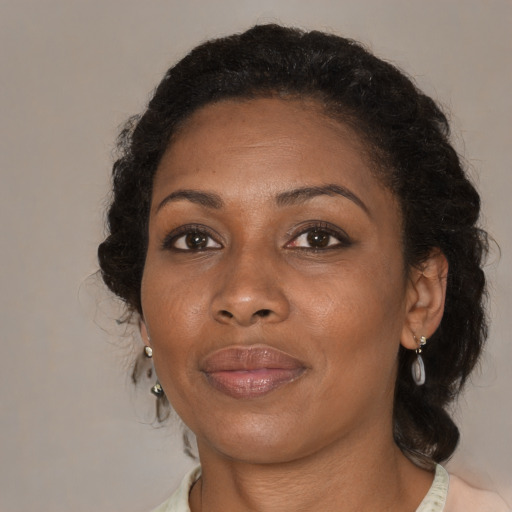 Joyful black adult female with medium  brown hair and brown eyes