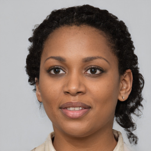 Joyful black young-adult female with short  black hair and brown eyes