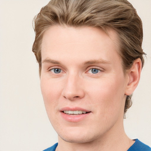 Joyful white young-adult male with short  brown hair and blue eyes