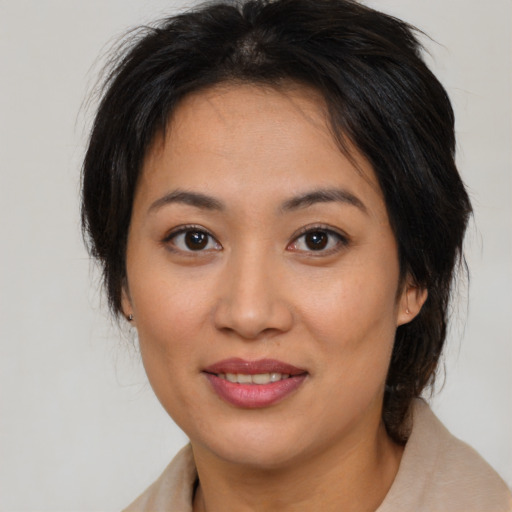 Joyful asian young-adult female with medium  brown hair and brown eyes