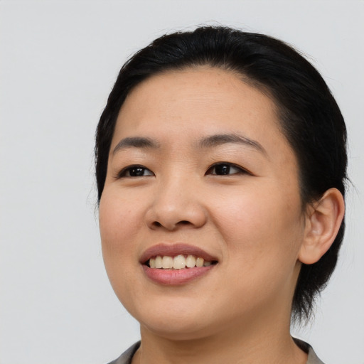 Joyful asian young-adult female with medium  black hair and brown eyes