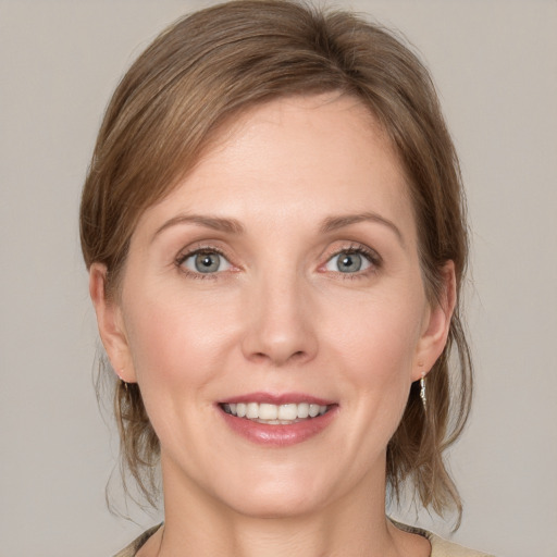 Joyful white young-adult female with medium  brown hair and blue eyes