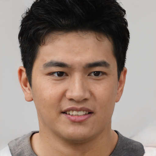 Joyful asian young-adult male with short  brown hair and brown eyes