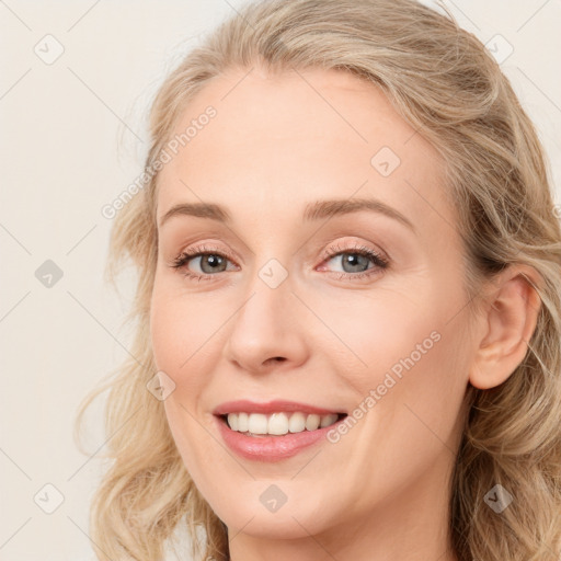 Joyful white young-adult female with long  brown hair and blue eyes