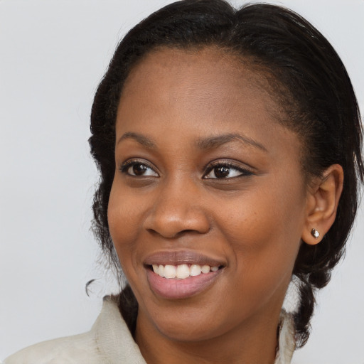 Joyful black young-adult female with long  brown hair and brown eyes