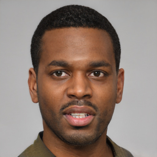 Joyful black young-adult male with short  black hair and brown eyes