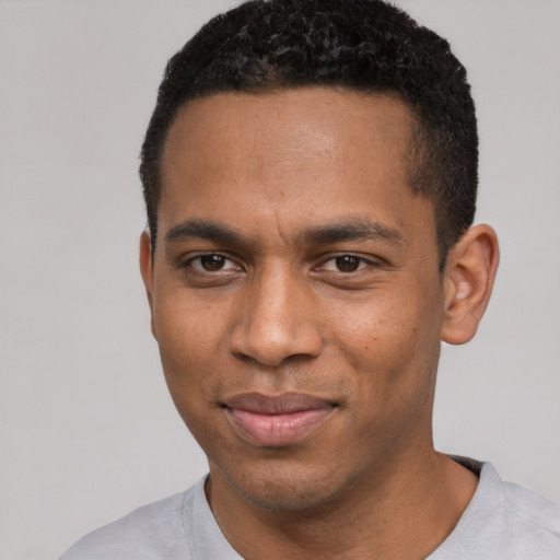 Joyful black young-adult male with short  black hair and brown eyes