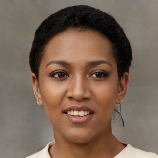 Joyful black young-adult female with short  black hair and brown eyes