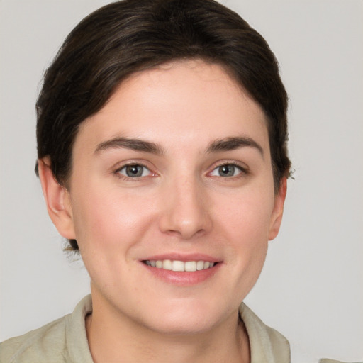 Joyful white young-adult female with short  brown hair and grey eyes