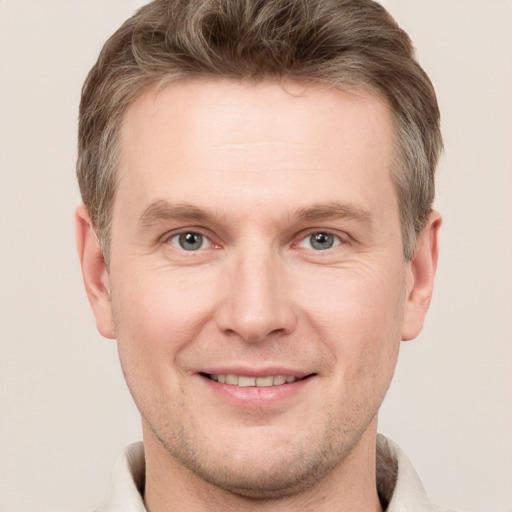 Joyful white adult male with short  brown hair and grey eyes