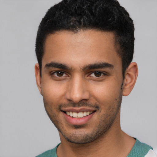 Joyful latino young-adult male with short  brown hair and brown eyes