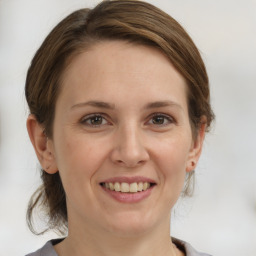 Joyful white young-adult female with medium  brown hair and grey eyes