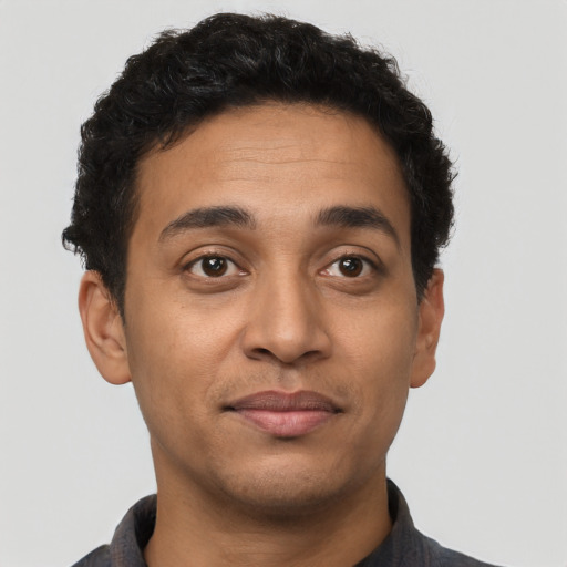 Joyful latino young-adult male with short  brown hair and brown eyes