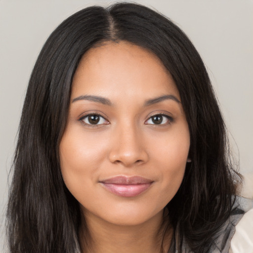 Joyful latino young-adult female with long  brown hair and brown eyes