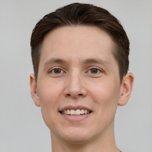 Joyful white young-adult male with short  brown hair and green eyes