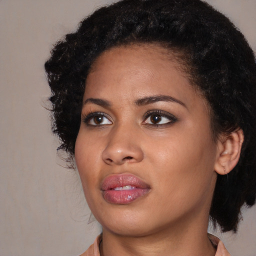 Joyful black young-adult female with medium  black hair and brown eyes