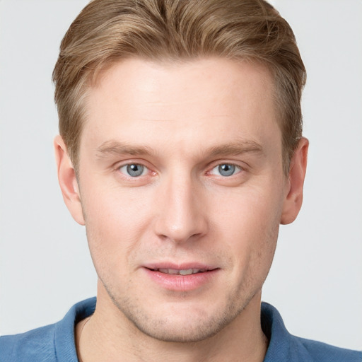 Joyful white young-adult male with short  brown hair and blue eyes