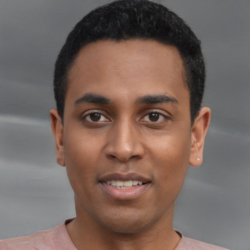 Joyful black young-adult male with short  black hair and brown eyes