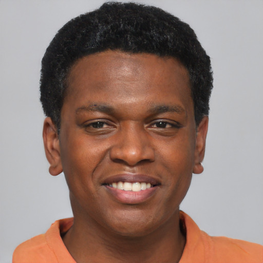 Joyful black young-adult male with short  brown hair and brown eyes