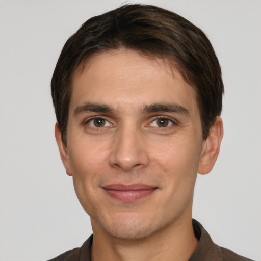 Joyful white young-adult male with short  brown hair and grey eyes