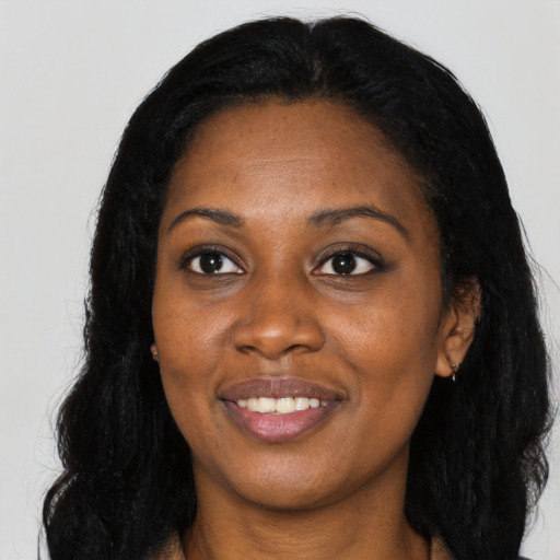 Joyful black adult female with long  black hair and brown eyes