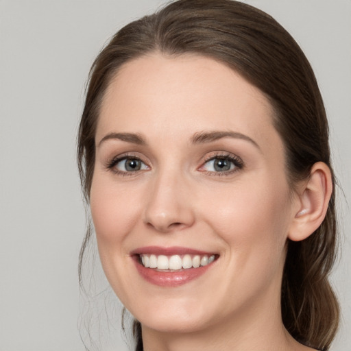 Joyful white young-adult female with long  brown hair and grey eyes