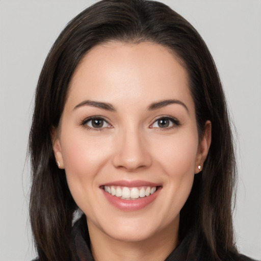 Joyful white young-adult female with long  brown hair and brown eyes