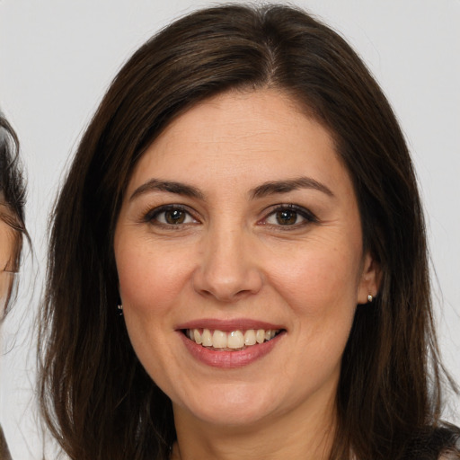 Joyful white young-adult female with long  brown hair and brown eyes