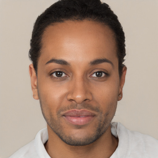 Joyful black young-adult male with short  brown hair and brown eyes