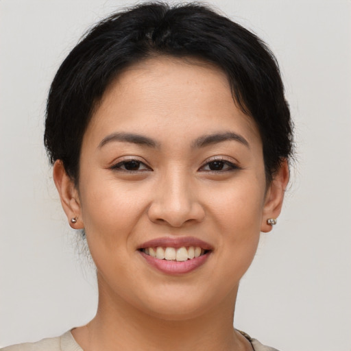 Joyful asian young-adult female with short  brown hair and brown eyes