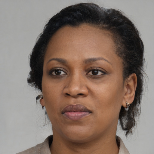 Joyful black adult female with medium  brown hair and brown eyes
