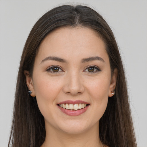 Joyful white young-adult female with long  brown hair and brown eyes