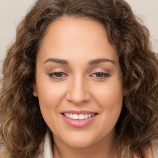 Joyful white young-adult female with long  brown hair and brown eyes