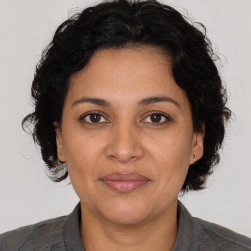 Joyful latino adult female with medium  brown hair and brown eyes