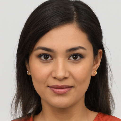 Joyful latino young-adult female with long  brown hair and brown eyes