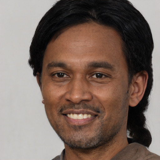 Joyful latino adult male with short  black hair and brown eyes