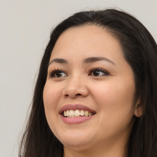 Joyful asian young-adult female with long  brown hair and brown eyes