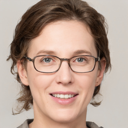 Joyful white adult female with medium  brown hair and grey eyes