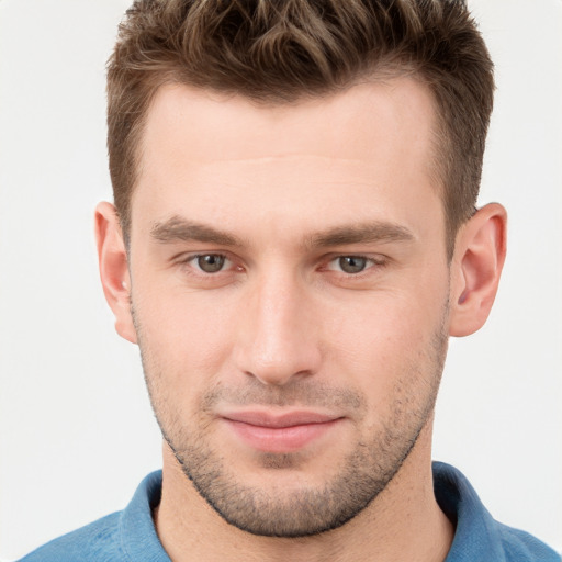 Joyful white young-adult male with short  brown hair and grey eyes