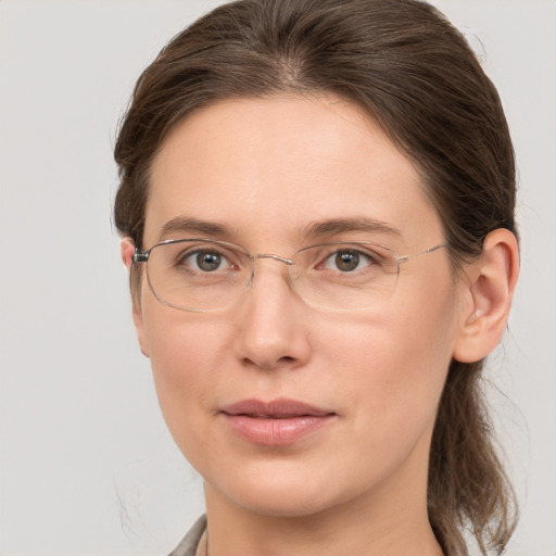 Joyful white adult female with medium  brown hair and grey eyes