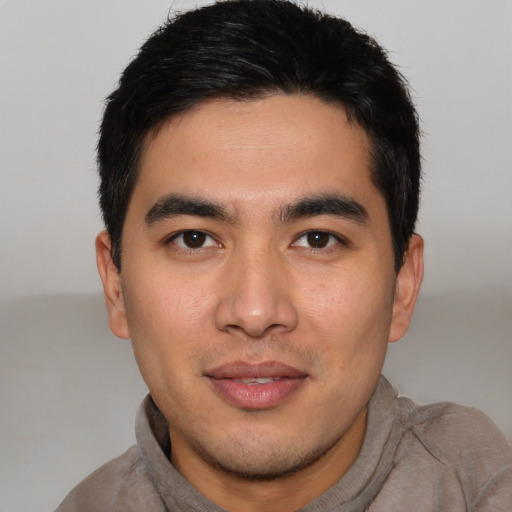 Joyful asian young-adult male with short  black hair and brown eyes
