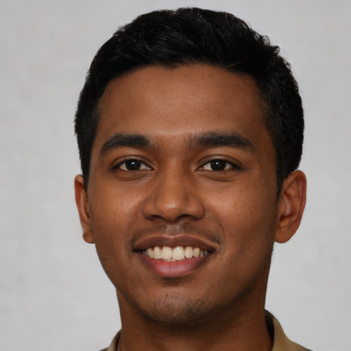 Joyful black young-adult male with short  black hair and brown eyes