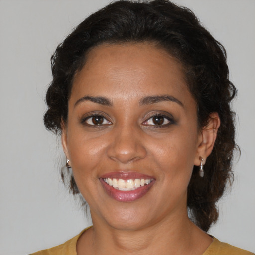 Joyful black adult female with medium  brown hair and brown eyes
