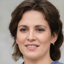 Joyful white young-adult female with medium  brown hair and green eyes