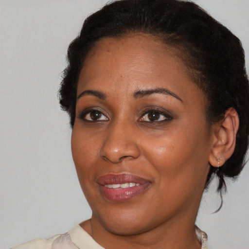 Joyful black adult female with medium  brown hair and brown eyes